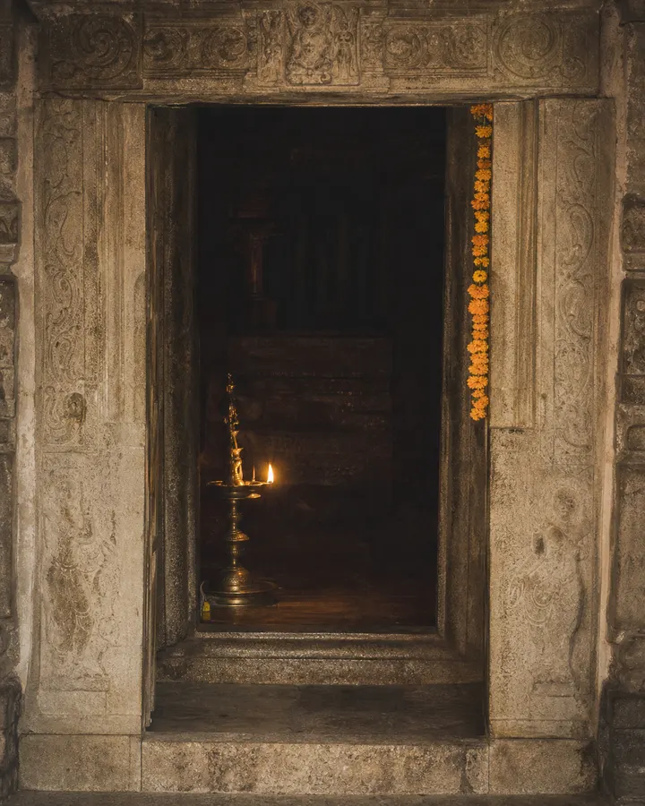 The sanctum doorway with a single oil lamp burning beside the threshold.